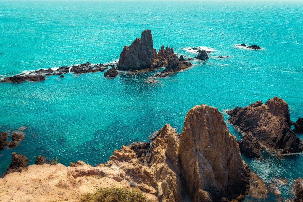 A body of water with rocks in the middle.