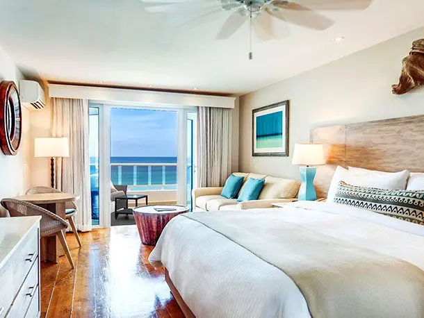 A bedroom with a view of the ocean and a bed.