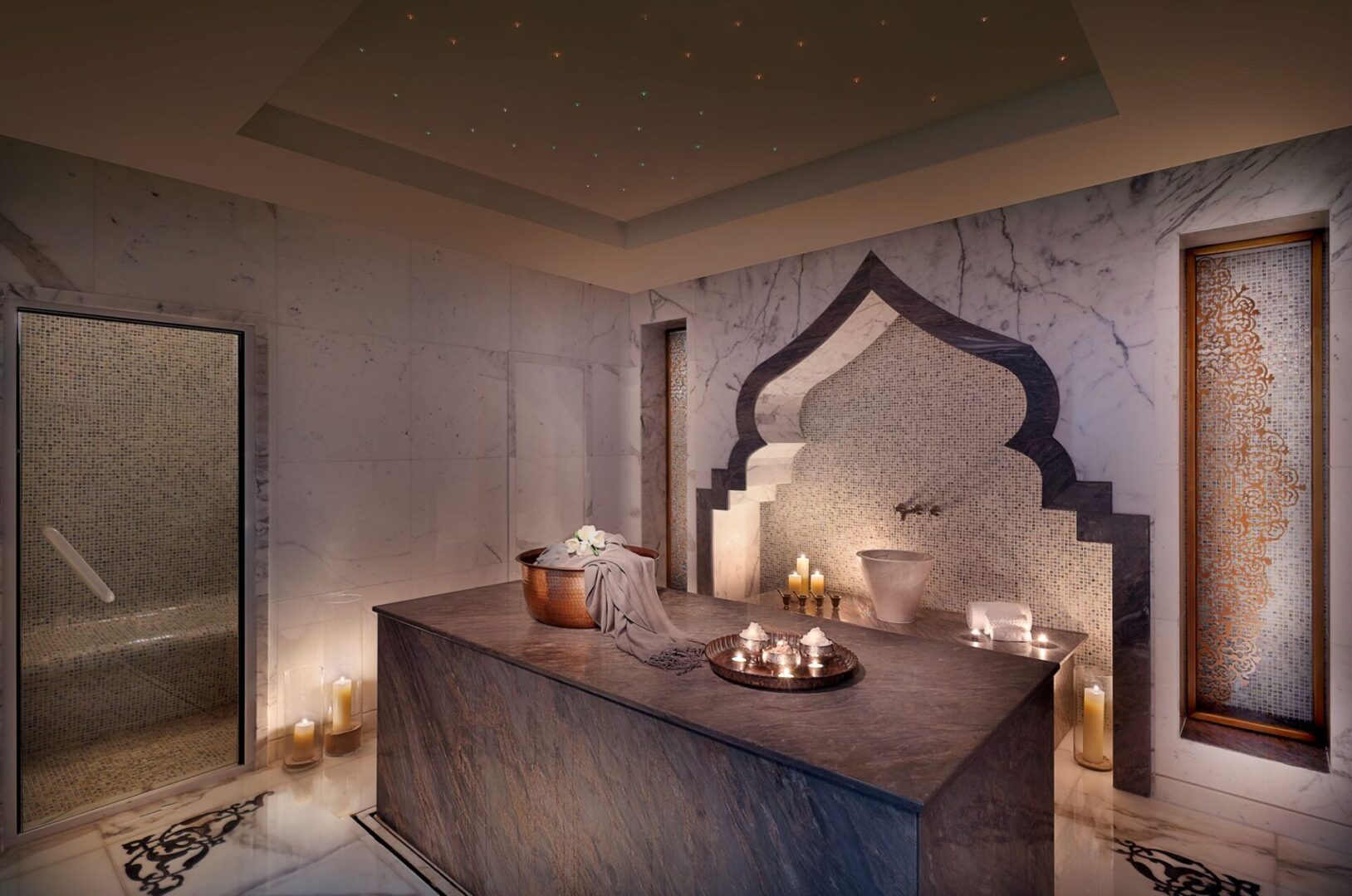 A spa room with candles and a large stone table.