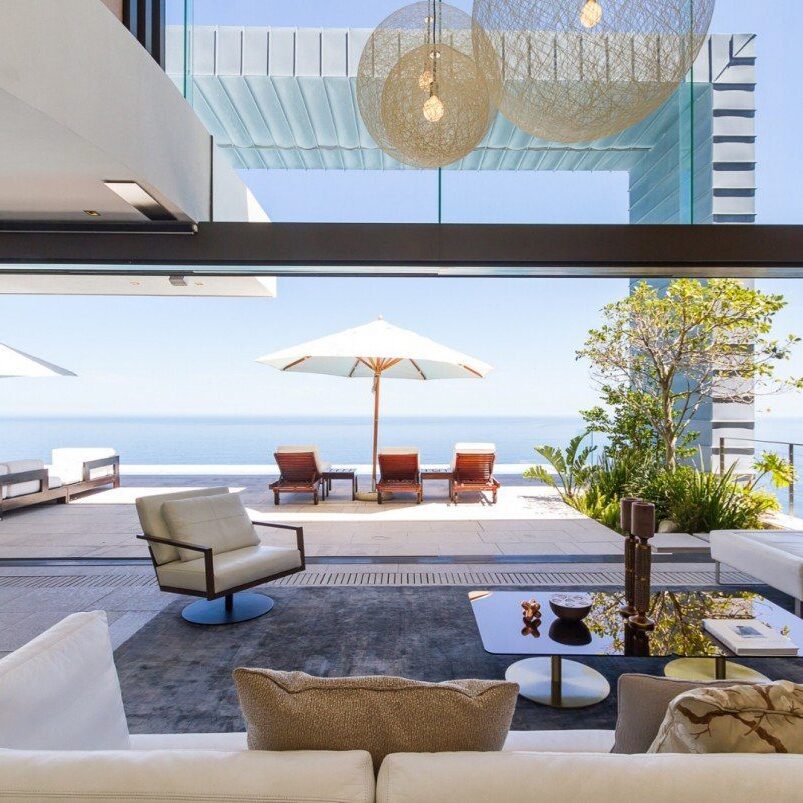 A living room with an ocean view and furniture.